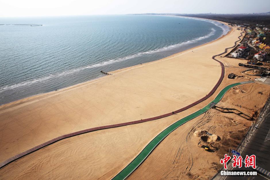 3月13日，秦皇島萬(wàn)米臨海沙灘木棧道。據了解，該木棧道全長(cháng)約4200米，與北戴河區原有的7500米木棧道對接后全線(xiàn)總長(cháng)度1.17萬(wàn)米，整個(gè)木棧道東起秦皇島體育基地游船碼頭，西至北戴河濕地公園，呈波浪形蜿蜒10.4公里海岸線(xiàn)。 中新社發(fā) 曹建雄 攝 CNSPHOTO