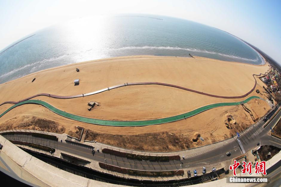 3月13日，秦皇島萬(wàn)米臨海沙灘木棧道。據了解，該木棧道全長(cháng)約4200米，與北戴河區原有的7500米木棧道對接后全線(xiàn)總長(cháng)度1.17萬(wàn)米，整個(gè)木棧道東起秦皇島體育基地游船碼頭，西至北戴河濕地公園，呈波浪形蜿蜒10.4公里海岸線(xiàn)。 中新社發(fā) 曹建雄 攝 CNSPHOTO